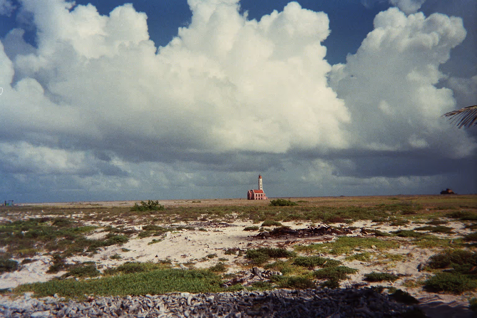 The pink lighthouse on Klein Curaçao from the air, the flat island around it