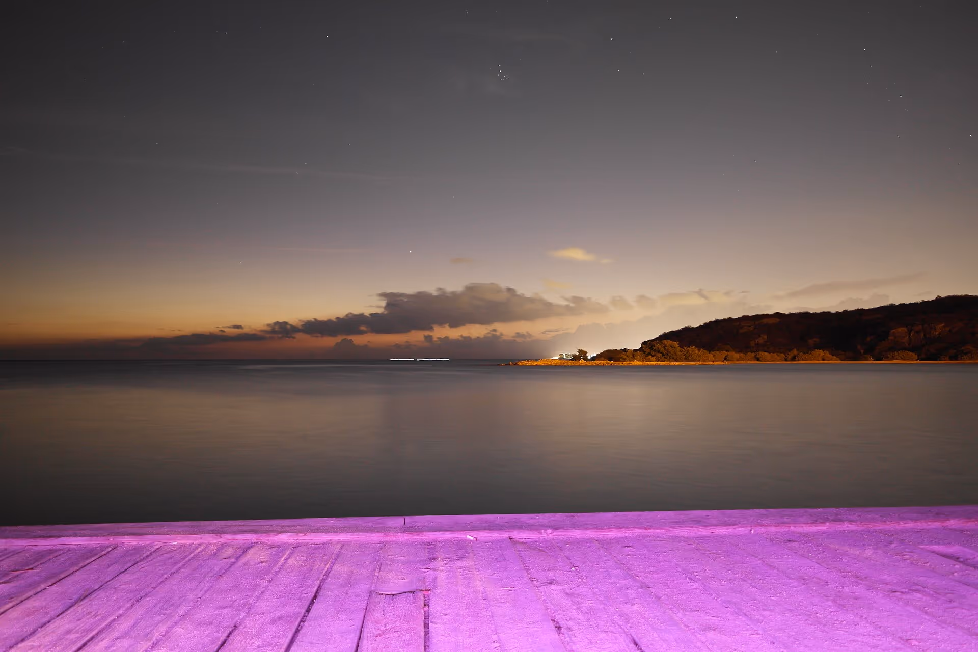 Caracasbaai at night in a long exposure, lights reflected on still water