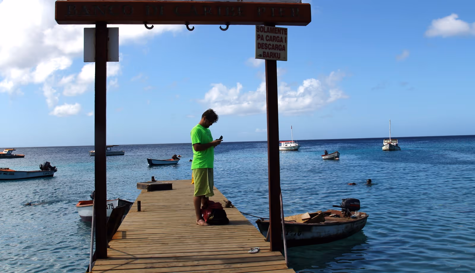 The fishermen's pier at Playa Grandi (Playa Piskadó), Westpunt, with fishing boats and snorkellers