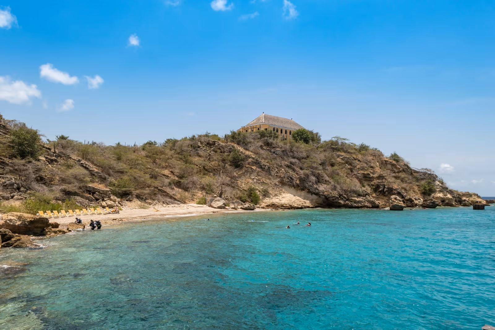 Tugboat Beach at Caracasbaai: the cove and the yellow Quarantine building above it